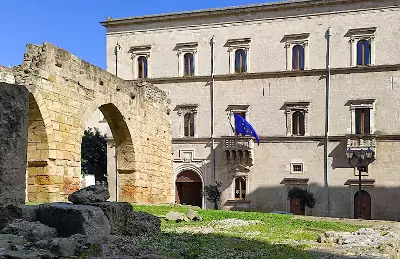 La facciata di Palazzo Granafei-Nervegna e l'arco di epoca romana sulla piazza antistante.