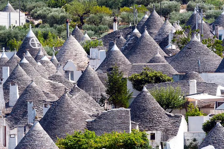 Una panoramica di tanti trulli ad Alberobello, uno dei luoghi più iconici della Puglia.